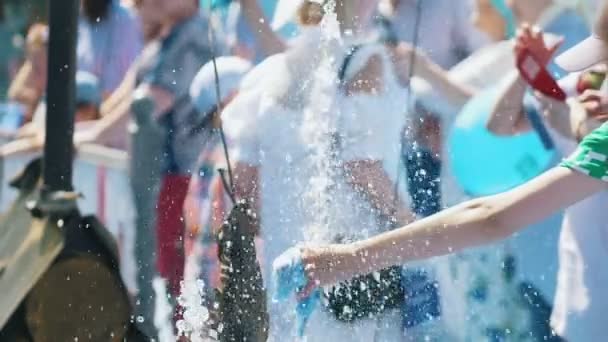 La mano femenina sostiene la taza de plástico en el agua salpicada — Vídeos de Stock