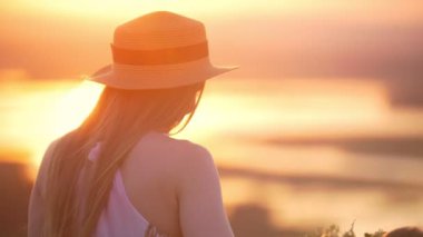 Şapka ve küçük kızı Genç Anne git gün batımına doğru yürür