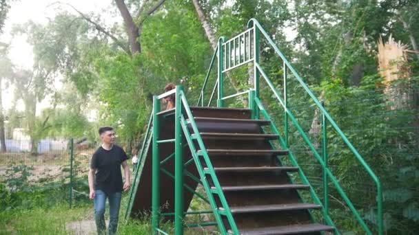 Jeune homme marchant avec son chien courant dans les escaliers dans l'aire de jeux d'entraînement à l'extérieur — Video