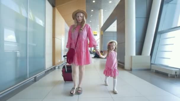 Mor och dotter resenärer med resväskor som går ner till den internationella flygplatsen — Stockvideo