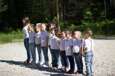 Beyaz t-shirt ile boyalı yüzler yaz günde sıraya dizilmiş küçük çocuklarda