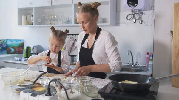 Güzel anne ve küçük kızı birlikte krep pişirme