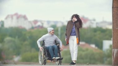 Mutlu adam tekerlekli şehir sokak çalışan mutlu genç kadınla devre dışı