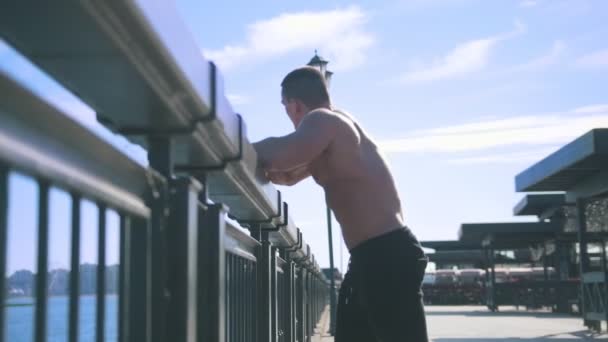 一个肌肉发达的男人向大海望去 — 图库视频影像