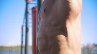 Güçlü bir adam karın kasları spor Park sallıyor.