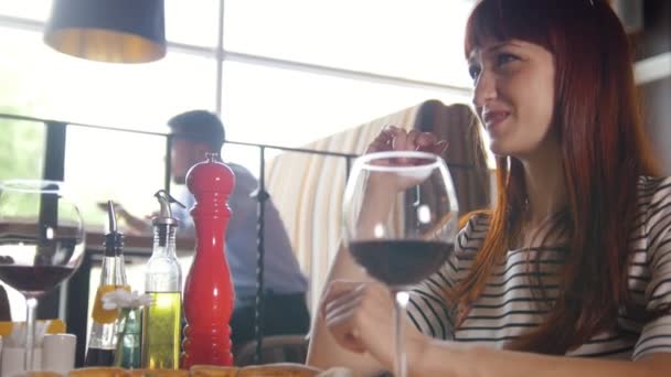 El tipo le cuenta un chiste a una chica en un restaurante — Vídeos de Stock