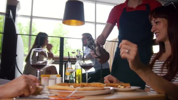 Kelner nalewa wino dla młodej pary w kawiarni — Wideo stockowe