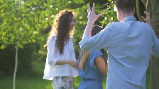 Mladí šťastní přátelé baví tanec v letním parku — Stock video