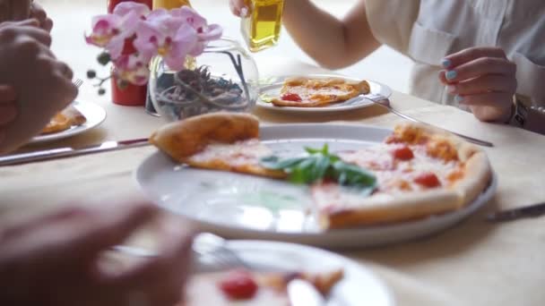 Jóvenes amigos se reúnen en un restaurante comiendo pizza bebiendo alcohol y contando historias — Vídeo de stock