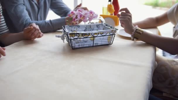 Руки офіціанта служать посуду на столі для молодих людей — стокове відео