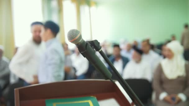 Das Mikrofon auf dem Schreibtisch vor der Menge muslimischer Menschen auf einer Massenkundgebung — Stockvideo