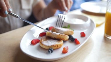 Yazlık cheescakes kafede kahvaltı sırasında yeme kız