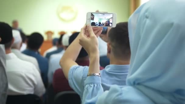 Achteraanzicht van Islamitische mensen op de Islamitische Conferentie - vrouwen in hijab schieten op smartphone — Stockvideo