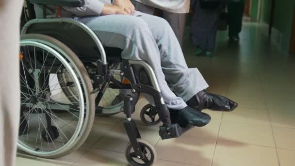 Disabled man on a wheelchair standing inside hospital or university — Stock Video