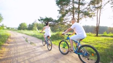 Genç mutlu çift yaz alanında yolda Bisiklete binme