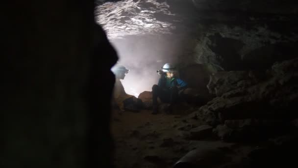 Дети рассматривают и сидят в пещере undeground — стоковое видео
