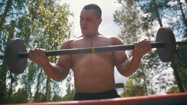 강한 근육 질의 남자 오래 된 무거운 철 크로스바 야외에서와 약혼 — 비디오