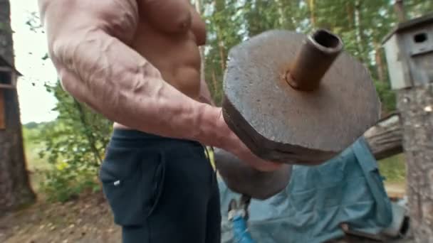 Nehéz vas kézzel súlyzó edzés izmos ember kezében erdő — Stock videók