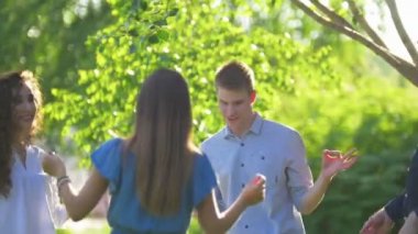 Genç mutlu arkadaşlar yaz parkında dans ederken eğleniyorlar.