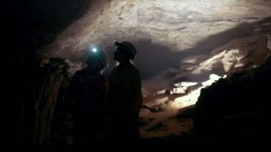 El feneri ile genç grup karanlık bir mağarada geliyor