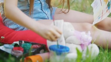 Elinde çocuk yaz çim üzerinde oturan fırça ile çizim