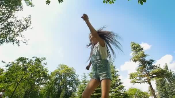 Щаслива маленька дівчинка з довгим волоссям розважається в літньому парку — стокове відео