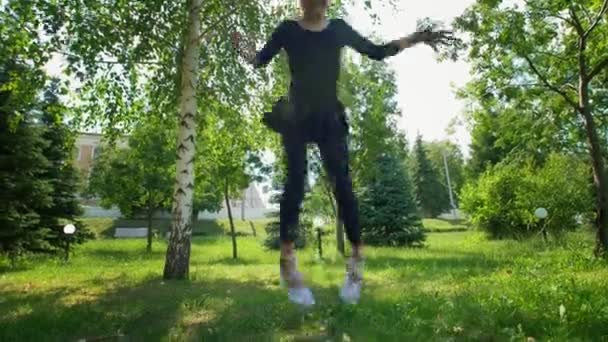 Menina bonito fazendo ginástica fio na grama no parque no dia ensolarado — Vídeo de Stock