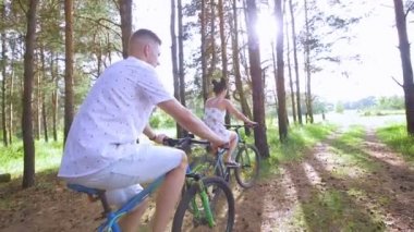 Genç adam ve kadın çam ormanda Bisiklete binme