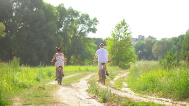 Vue arrière de jeunes couples faisant du vélo sur la route de campagne le jour de l'été — Video