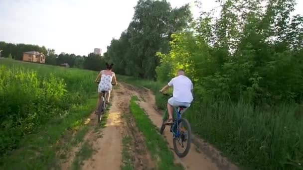 Vonzó fiatal pár élvezi a kerékpározás a nyári erdőben — Stock videók