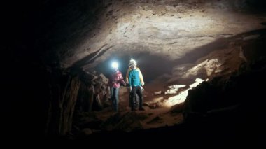 El feneri ile genç grup karanlık bir mağarada geliyor