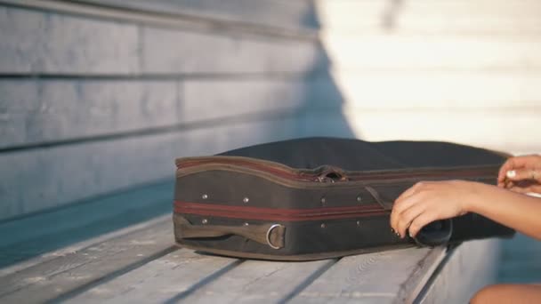 Young woman pulls her violin from the case outdoors at sunshine — Stock Video