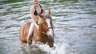 Mutlu genç kadın eğleniyor nehre at binmek