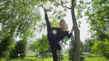 Jimnastik egzersizleri çim yaz, ağır çekim yapıyor güzel küçük kız