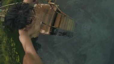 Genç adam rıhtımdan açık mavi göle atlar.