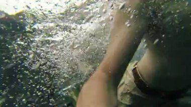 Mutlu genç adam yüzme açık mavi gölde eğleniyor