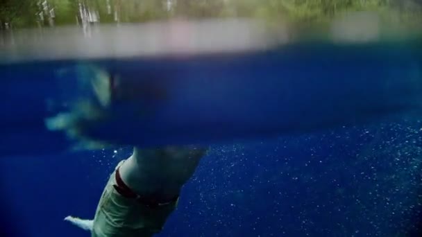 Young man enjoys swimming underwater in the clear lake — Stock Video