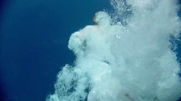 Joven se sumerge en el lago azul profundo — Vídeo de stock