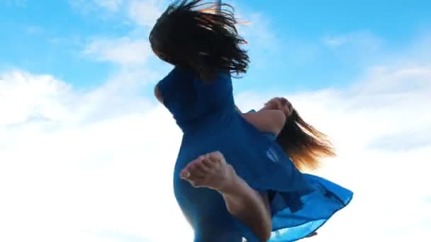 Дві жіночі гірлянди в блакитних сукнях, що обертаються на пілоні на фоні блакитного неба на відкритому повітрі — стокове відео