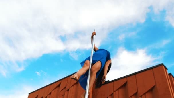 Jonge vrouw in blauwe jurk dansen pole-dans buitenshuis — Stockvideo
