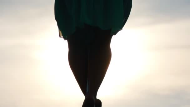 La silueta de las piernas de la mujer joven sube sobre el pilón al atardecer — Vídeos de Stock