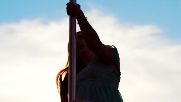 Hübsche junge Pole-Tänzerin hält sich im Freien am Pylon fest — Stockvideo