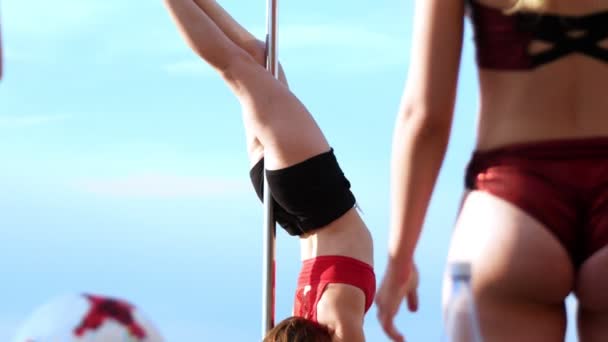 Mujeres jóvenes en lencería roja ejercitando pole-dance al aire libre en el día de verano — Vídeos de Stock