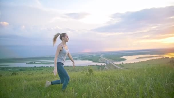 Mujer joven practicando acrobacia voltear a través del sol al atardecer — Vídeos de Stock