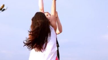 Açık havada pilon üzerinde dönen iki genç kadın