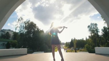 Çekici kadın Parkı önünde Keman çalmaya kemerin altında duruyor