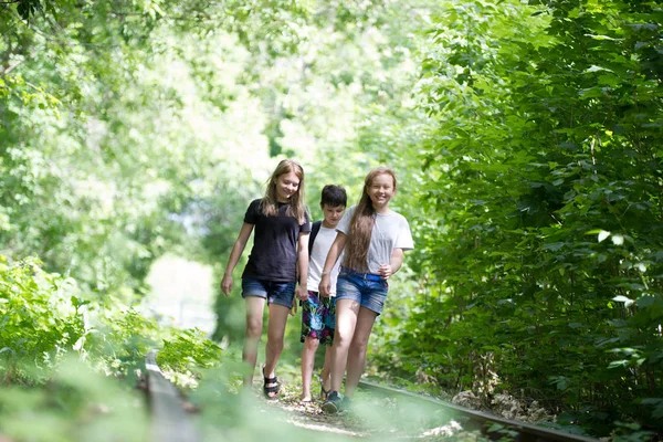 Niños caminando en el bosque en un ferrocarril abandonado — Foto de Stock