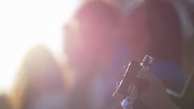 Arkadaşlar güneş altında çimlerde oturan bulutlar bakıyor