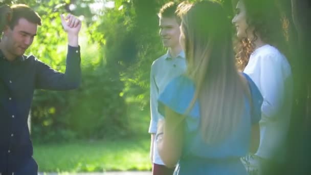 Jóvenes amigos felices divirtiéndose bailando en el parque de verano — Vídeos de Stock
