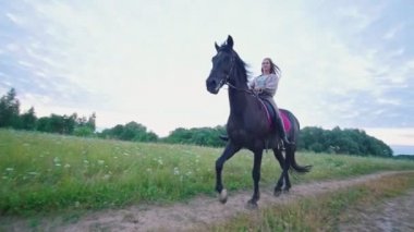 Çayır yol üzerinde at dörtnala üzerinde genç kadın Binicilik